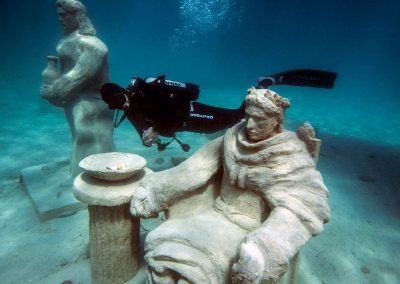 Via Crucis underwater museum man besides statue